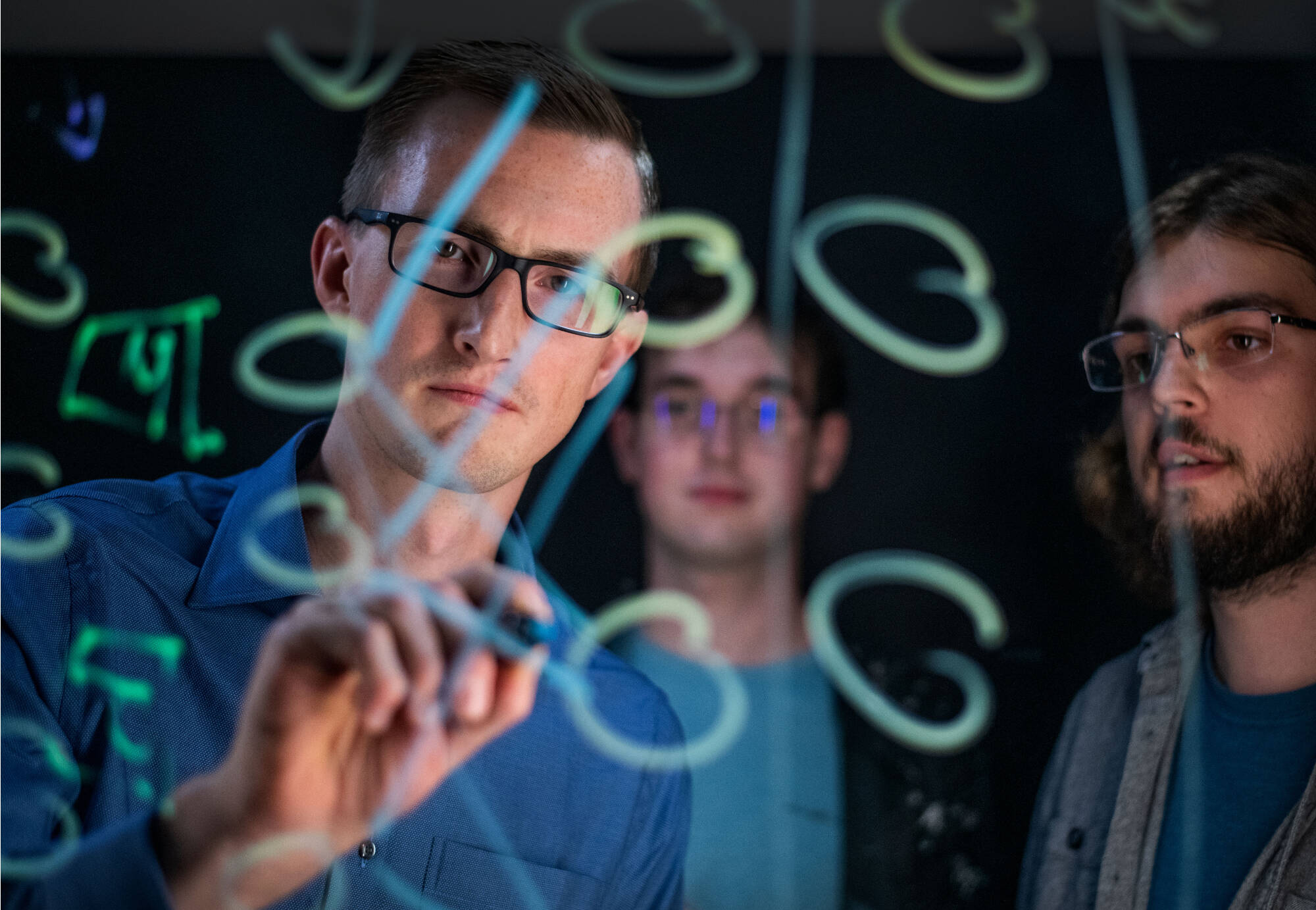 Zachary DeBruine, left, is an assistant professor of computing. Students are Seth Wolfgang, center, and Skylar Ruiter, right(Photo releases on file)